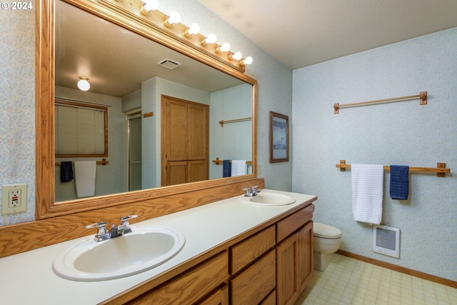 full bathroom featuring double vanity, a sink, toilet, and tile patterned floors