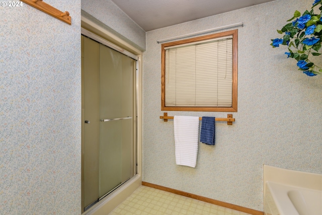 full bathroom with a stall shower, baseboards, a tub, and tile patterned floors