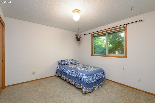 bedroom featuring a textured ceiling, carpet floors, and baseboards