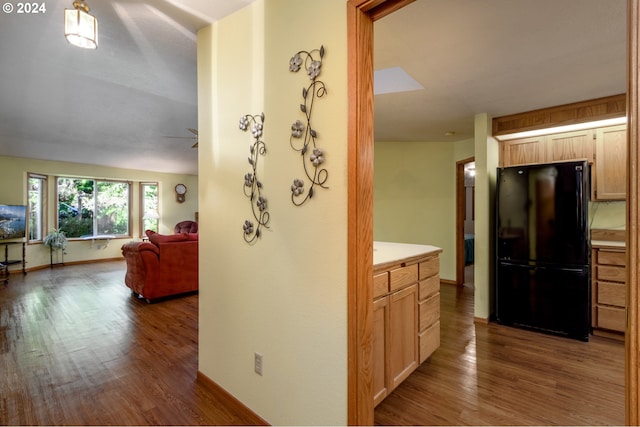 corridor featuring baseboards and wood finished floors