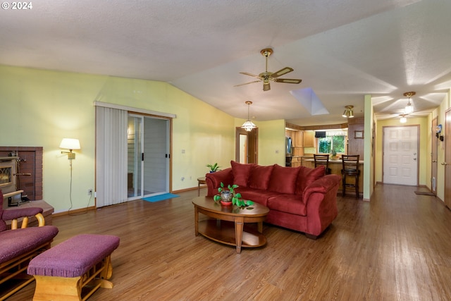 living room with a textured ceiling, lofted ceiling, ceiling fan, and hardwood / wood-style flooring