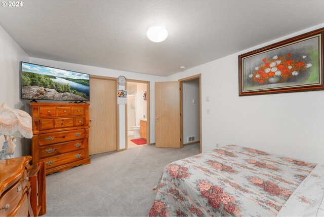 681 Hamlin Dr, Canyonville, OR 97417 - bedroom featuring light carpet, connected bathroom, and a textured ceiling