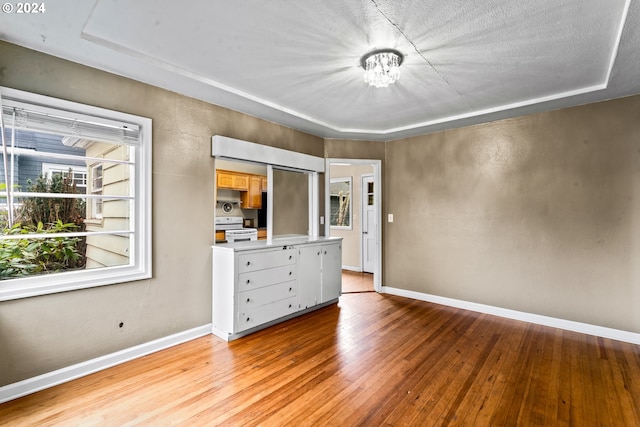 unfurnished bedroom featuring light hardwood / wood-style flooring, a chandelier, and a textured ceiling