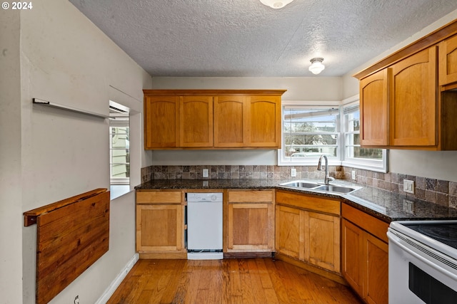 kitchen with electric range, sink, a textured ceiling, and light wood-type flooring