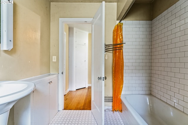 bathroom with a tub, tile patterned flooring, and sink