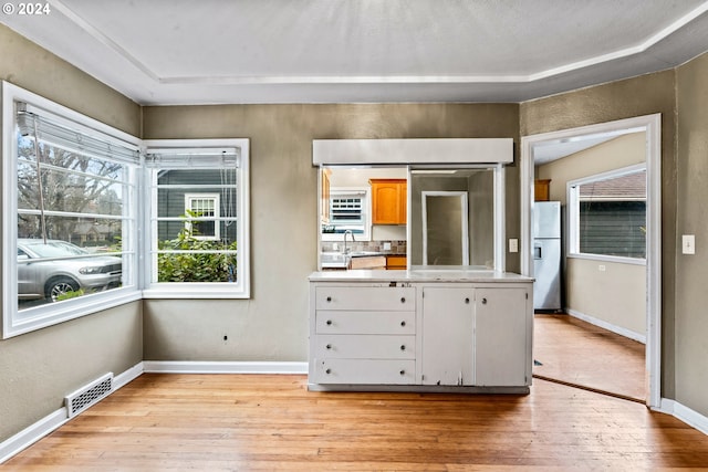 interior space featuring stainless steel fridge, light hardwood / wood-style flooring, and sink