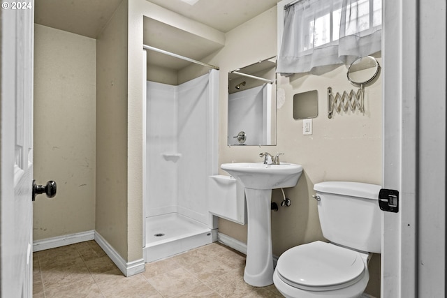 bathroom featuring a shower, tile patterned flooring, and toilet