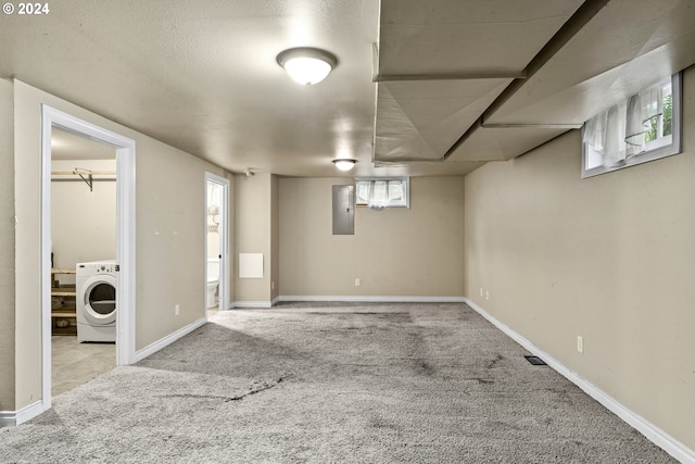 basement with a healthy amount of sunlight, light colored carpet, and washer / dryer