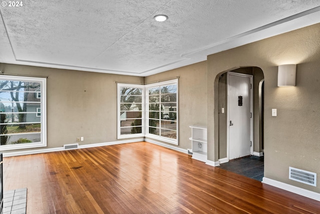 empty room featuring dark hardwood / wood-style floors and a textured ceiling