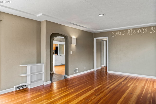 empty room featuring a textured ceiling and hardwood / wood-style flooring