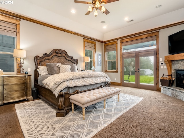 carpeted bedroom featuring ceiling fan, a stone fireplace, access to exterior, and french doors