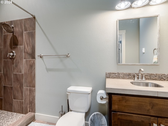 bathroom featuring vanity, toilet, and tiled shower