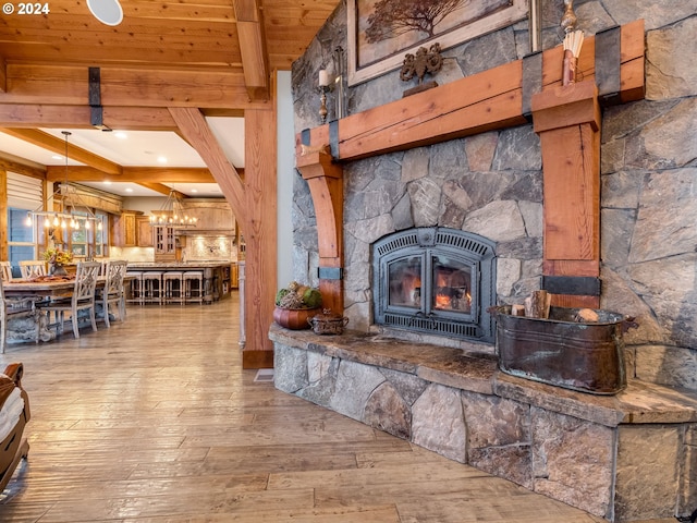 living room featuring a fireplace, wood-type flooring, wooden ceiling, and beamed ceiling