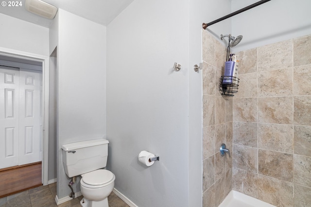 bathroom featuring toilet and a tile shower