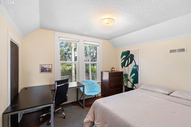 carpeted bedroom with lofted ceiling and a textured ceiling