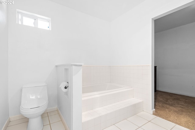 bathroom with tiled bath, tile patterned flooring, and toilet