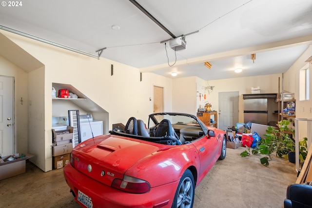 garage featuring a garage door opener and stainless steel fridge