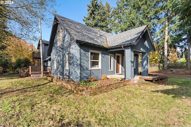 view of front of house with a deck and a front yard