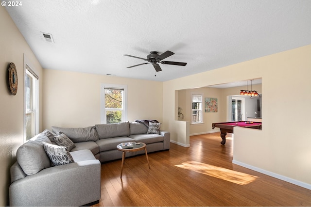 living room featuring hardwood / wood-style flooring, ceiling fan, a textured ceiling, and pool table