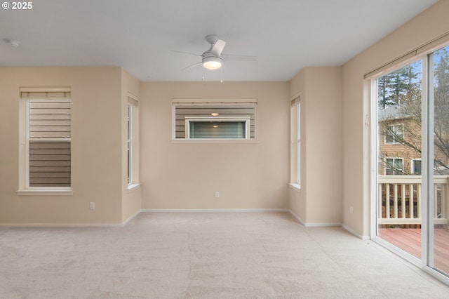 empty room with baseboards, a ceiling fan, and light colored carpet