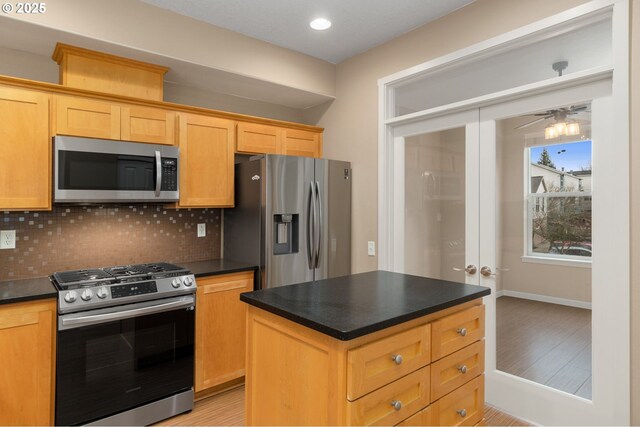 unfurnished room with baseboards, ceiling fan, and light colored carpet