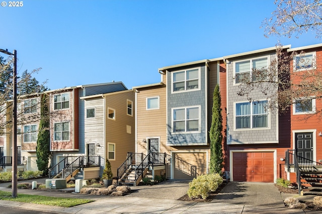 townhome / multi-family property featuring central AC, driveway, and an attached garage