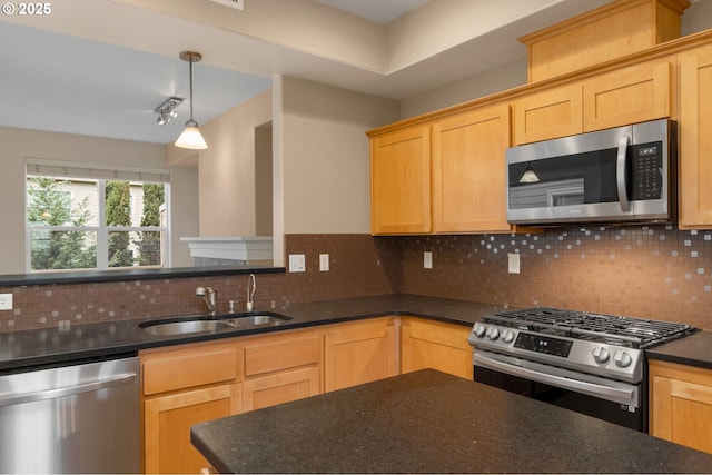 kitchen featuring stainless steel appliances, a sink, dark stone countertops, and tasteful backsplash