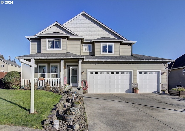 view of front of home featuring a front yard, a porch, and a garage