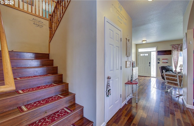 entryway with a textured ceiling and dark hardwood / wood-style floors