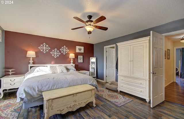 bedroom with ceiling fan, dark wood-type flooring, and a textured ceiling