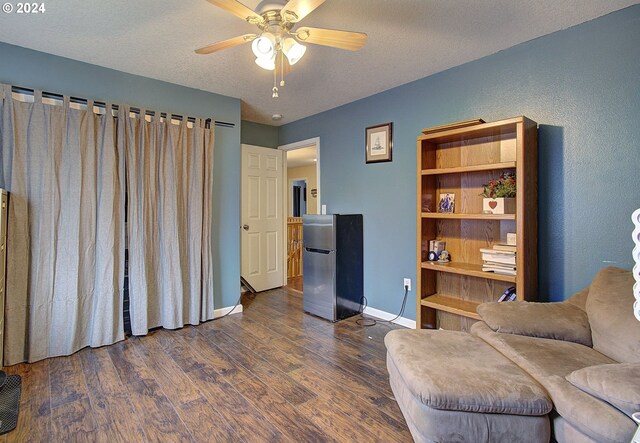 living area featuring a textured ceiling, ceiling fan, and dark wood-type flooring