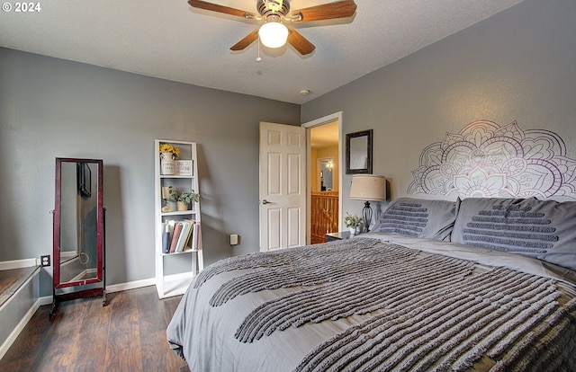 bedroom with ceiling fan, dark hardwood / wood-style flooring, and a textured ceiling