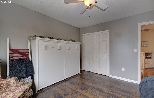 bedroom featuring a closet, ceiling fan, dark hardwood / wood-style flooring, and a textured ceiling