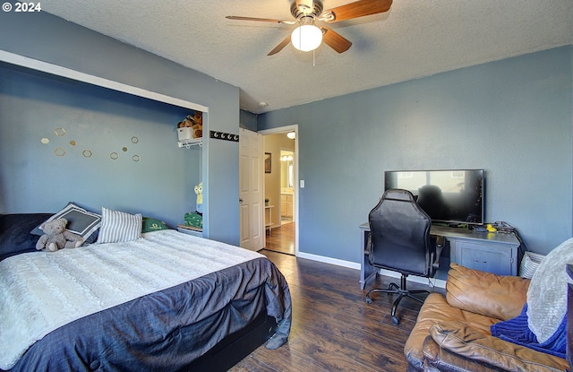 bedroom with a textured ceiling, ceiling fan, and dark wood-type flooring