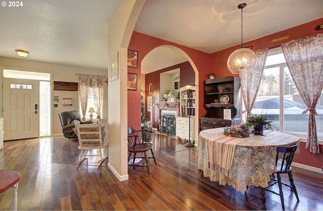 dining room featuring dark wood-type flooring and a textured ceiling