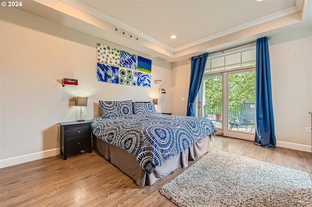 707 N Hayden Island Dr Unit 301, Portland, OR 97217 - bedroom with crown molding, a raised ceiling, access to exterior, baseboards, and wood-type flooring
