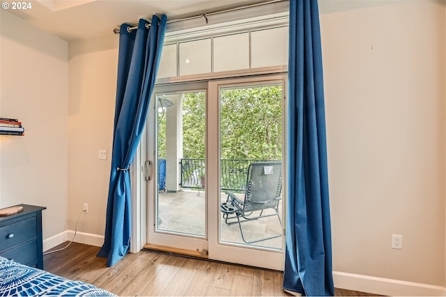 707 N Hayden Island Dr Unit 301, Portland, OR 97217 - unfurnished bedroom featuring baseboards, wood finished floors, and access to outside