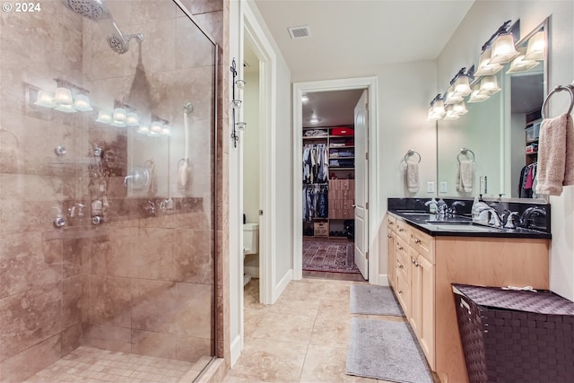 707 N Hayden Island Dr Unit 301, Portland, OR 97217 - full bathroom featuring a shower stall, vanity, a walk in closet, tile patterned floors, and toilet
