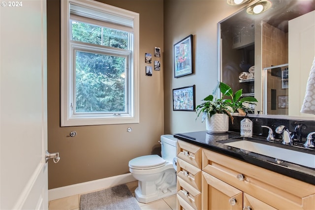 707 N Hayden Island Dr Unit 301, Portland, OR 97217 - bathroom featuring toilet, vanity, tile patterned floors, a tile shower, and baseboards