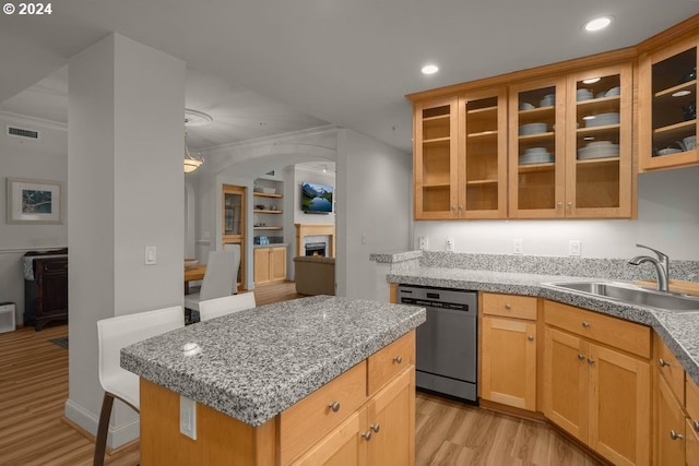 kitchen featuring ornamental molding, sink, a kitchen island, stainless steel dishwasher, and light hardwood / wood-style floors