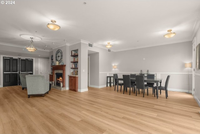 dining area with light wood-type flooring and crown molding