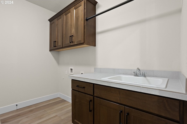 washroom with cabinets, washer hookup, sink, and light hardwood / wood-style flooring