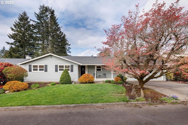 single story home with a front yard, a porch, and concrete driveway