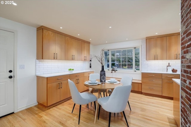 kitchen featuring recessed lighting, light wood-type flooring, light countertops, and backsplash