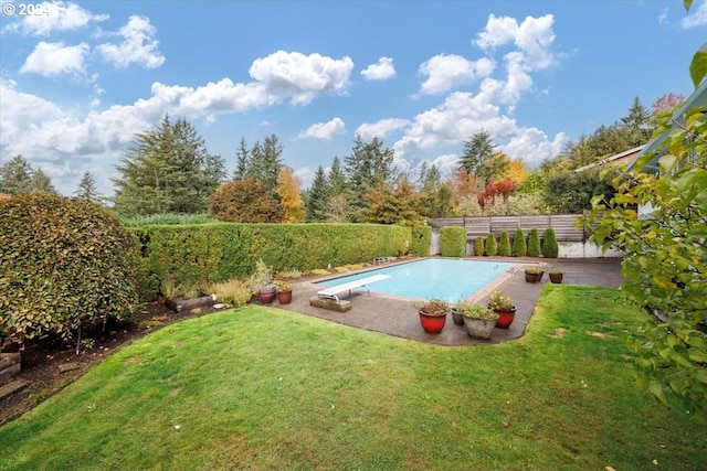 view of pool featuring a diving board and a yard