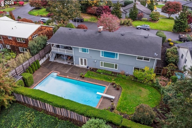 view of pool featuring a lawn, a diving board, and a patio area