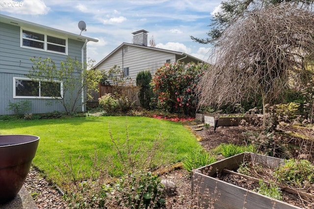 view of yard with fence and a vegetable garden