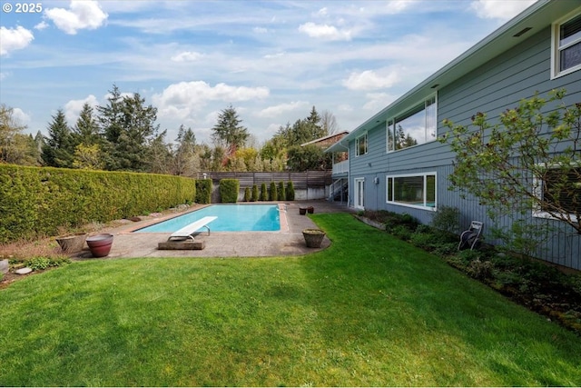 view of swimming pool featuring a diving board, a fenced backyard, a fenced in pool, and a lawn