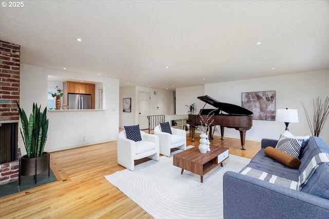 living room featuring a textured ceiling, light wood-type flooring, and a fireplace