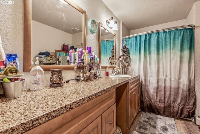 bathroom with vanity, hardwood / wood-style floors, and a textured ceiling